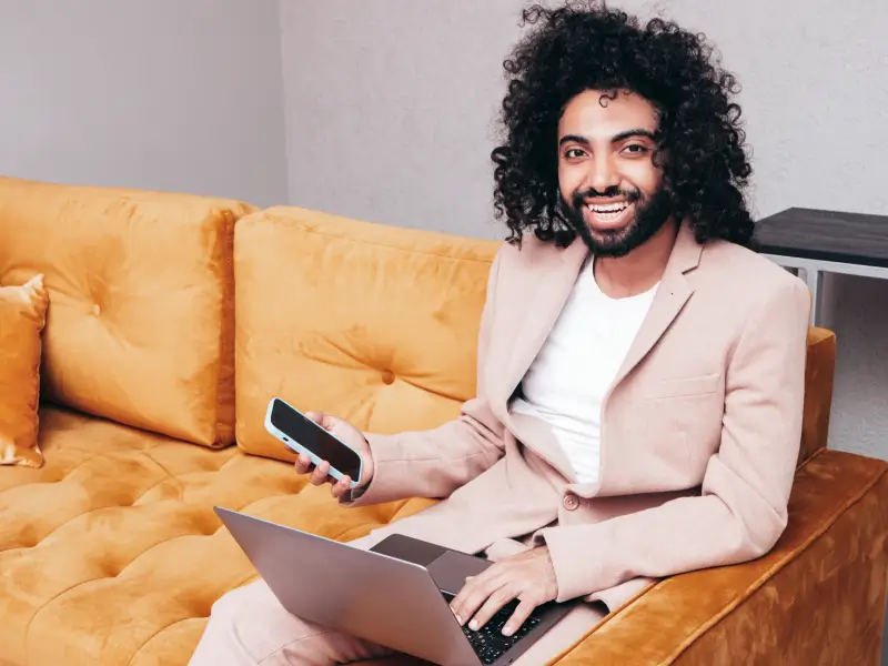a young man working on his computer, smiling